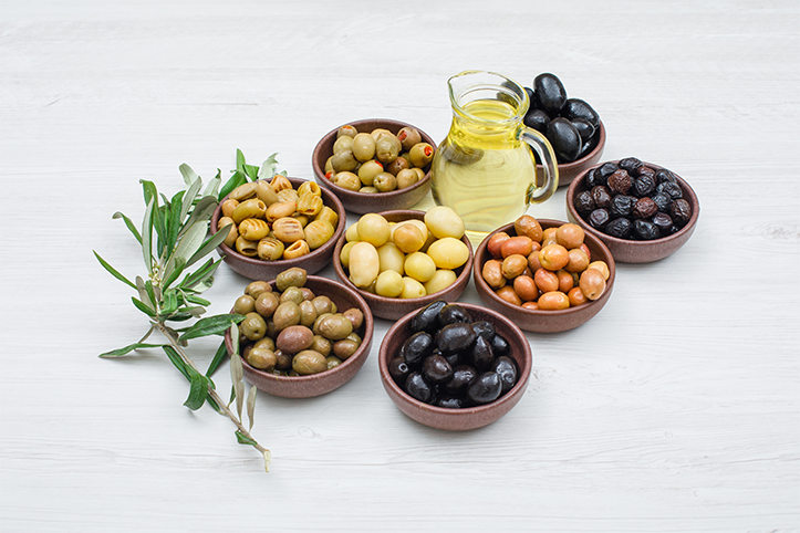 assorted variety olives clay bowls with olive leaves jar olive oil high angle view white wood